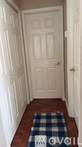 A hallway with a checkered rug on the floor.