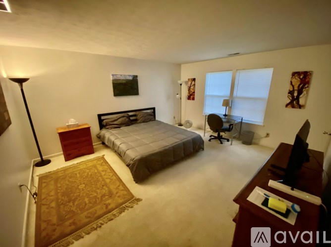 A bedroom with a bed, desk, and chair.