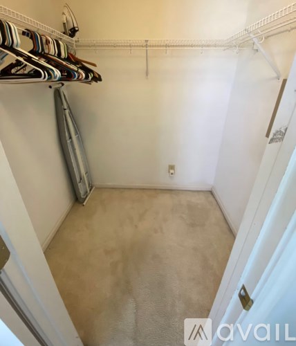 A small, empty room with a white door and a white wall.