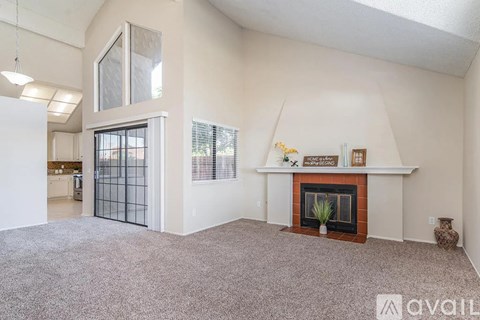 A living room with a fireplace and a carpet on the floor.