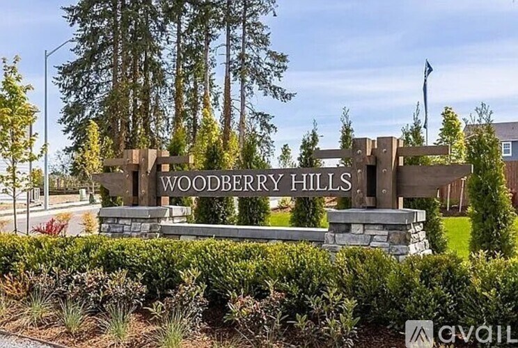 A sign that says Woodberry Hills is in front of some trees.