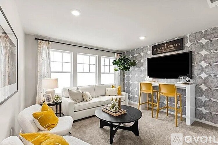 A living room with a white couch, yellow pillows, and a black coffee table.