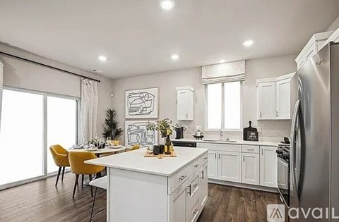 A modern kitchen with white cabinets and a large island.