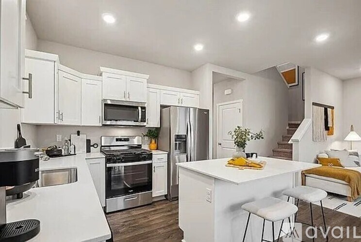 A kitchen with white cabinets and appliances.
