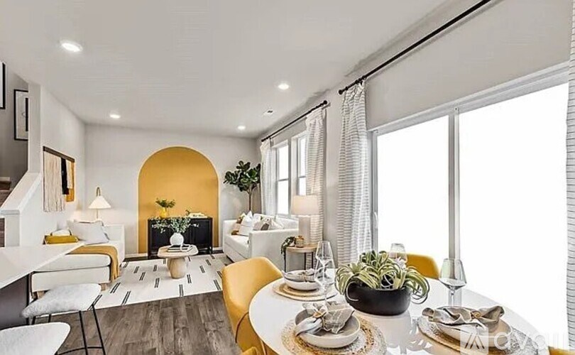 A modern dining room with a white table and yellow chairs.