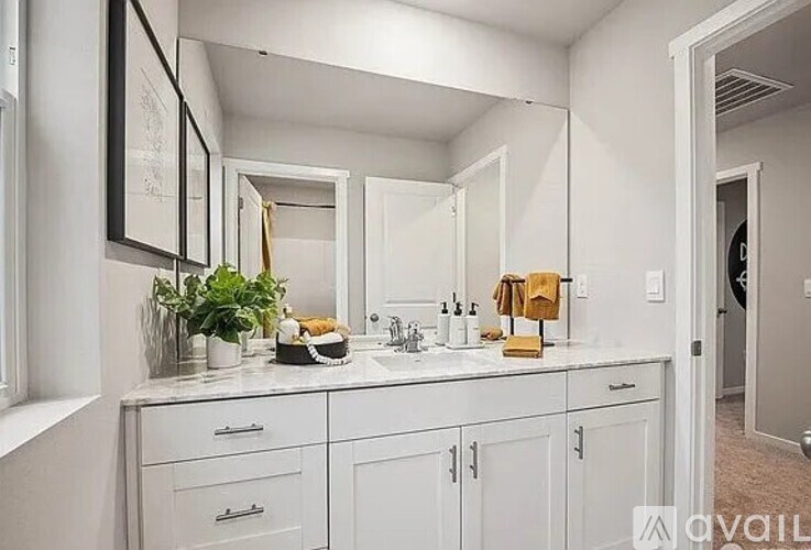 A bathroom with a white countertop and cabinets.