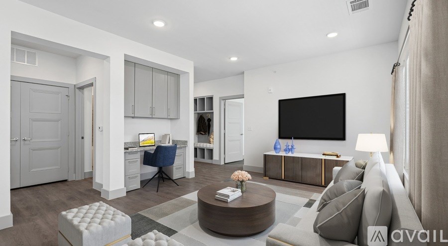A modern living room with a grey sofa, a coffee table, and a large TV on the wall.