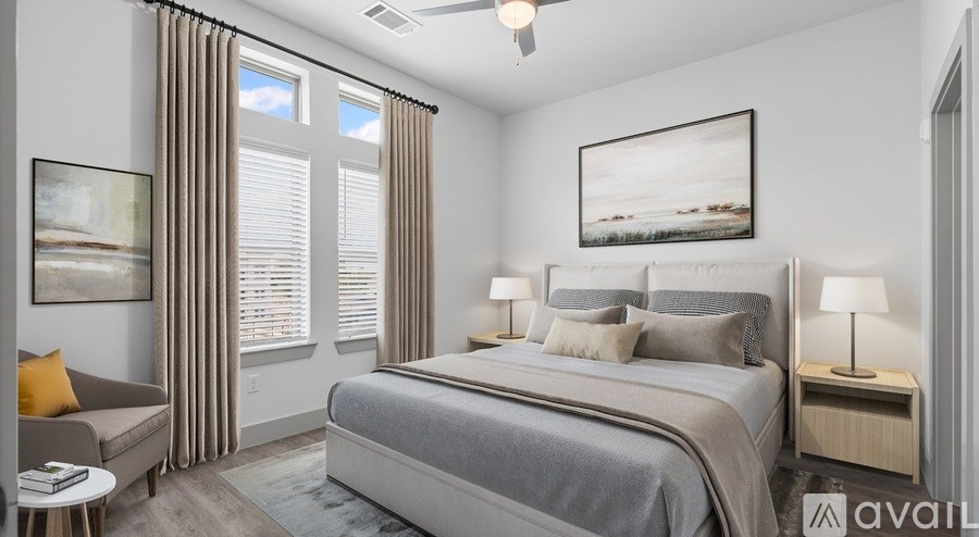 A bedroom with a large bed, a couch, and a ceiling fan.