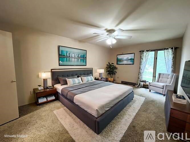 A bedroom with a large bed and a ceiling fan.