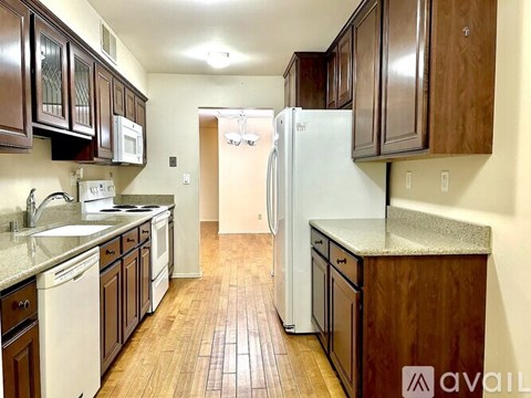 A kitchen with wooden cabinets and a white refrigerator.
