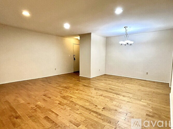 A room with wooden flooring and a chandelier.
