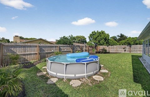 A hot tub sits in the middle of a grassy backyard.