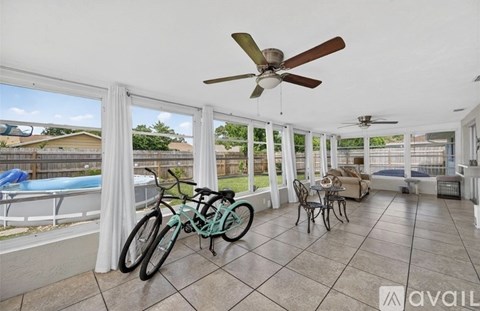 A room with a ceiling fan and a bicycle on the floor.