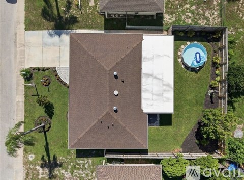 A house with a brown roof and a white wall with a blue sign that has the number 0 on it.