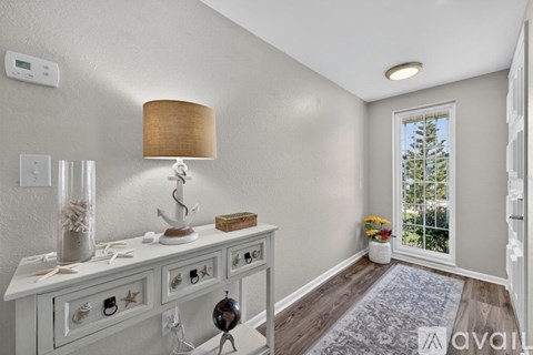 A well-lit room with a white console table and a lamp on it.