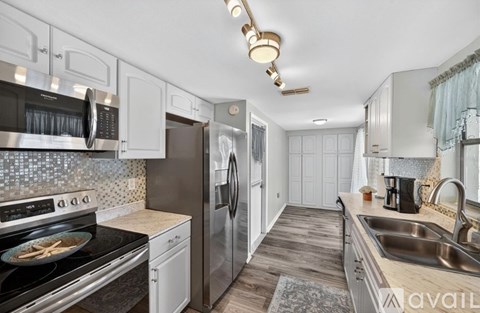A kitchen with white cabinets and a black stove top oven.