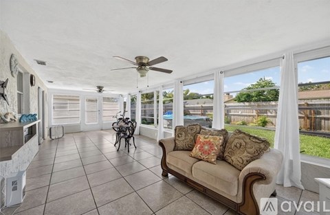 A living room with a couch, a fan, and a table.