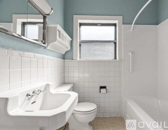 A white bathroom with a toilet, sink, and tub.