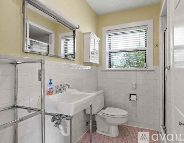 A bathroom with a sink, toilet, and mirror.