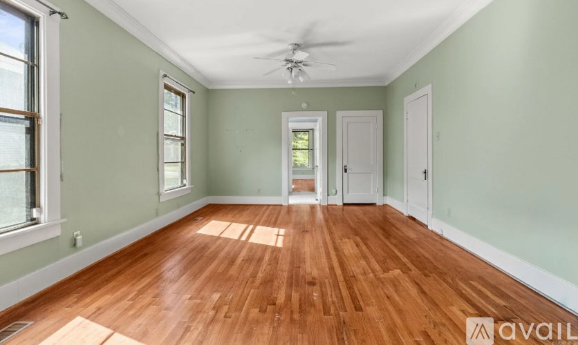 A room with wooden floors and a ceiling fan.