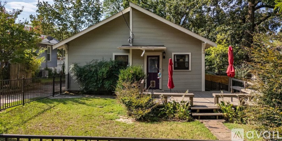 A small house with a red door and a porch.