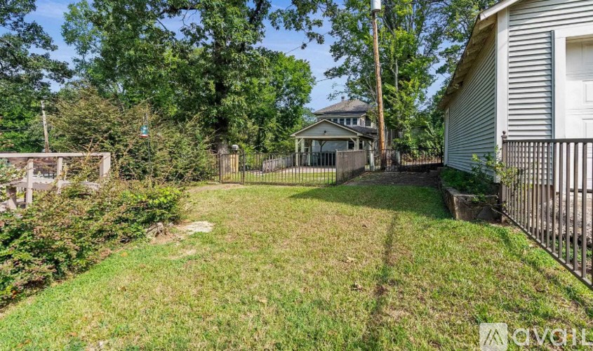 A backyard with a fence and a house in the background.