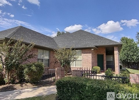 A house with a green door and a black fence.