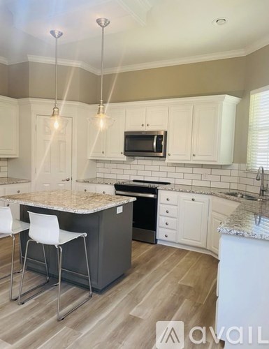 A kitchen with a granite countertop and white cabinets.