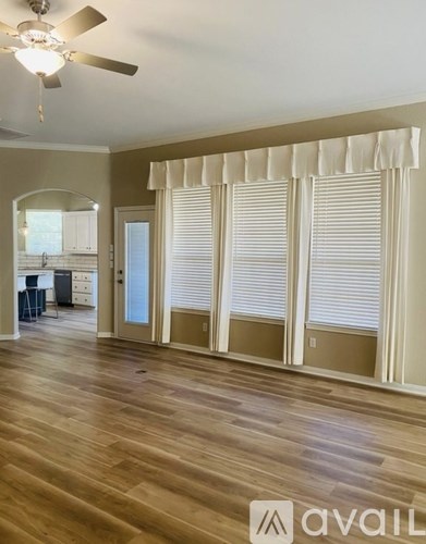 A room with wooden floors and a ceiling fan.