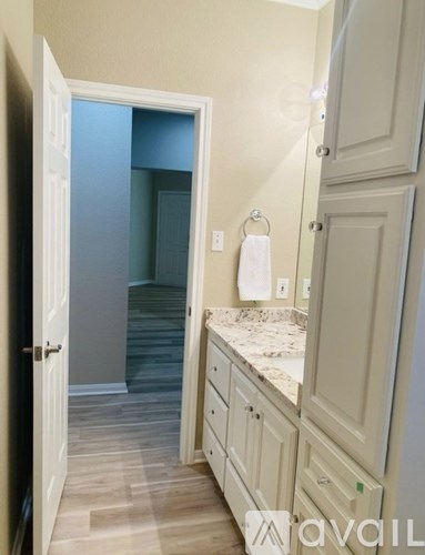 A bathroom with a white cabinet and a towel hanging on the wall.