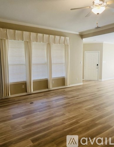 A room with wooden floors and a ceiling fan.