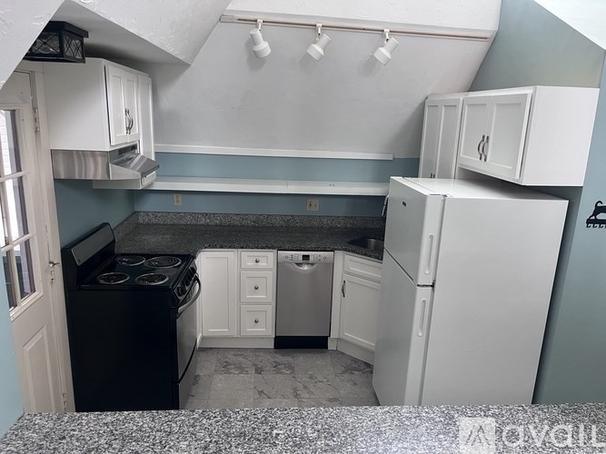 A kitchen with white cabinets and a black stove top oven.