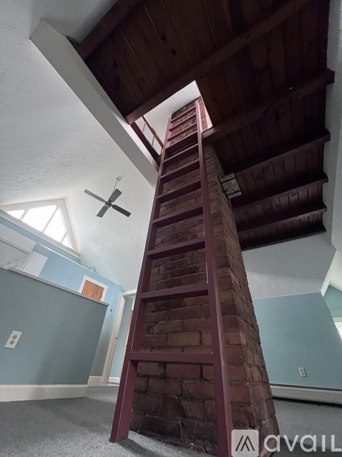 A tall wooden staircase leads up to a window.