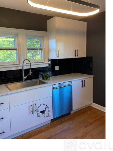 A kitchen with white cabinets and a blue dishwasher.