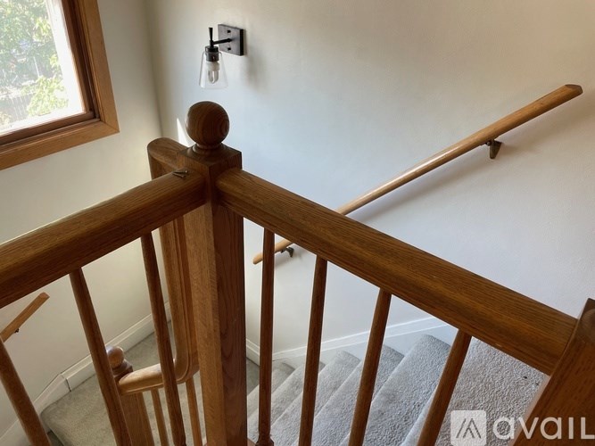 A staircase with a wooden railing and a window.