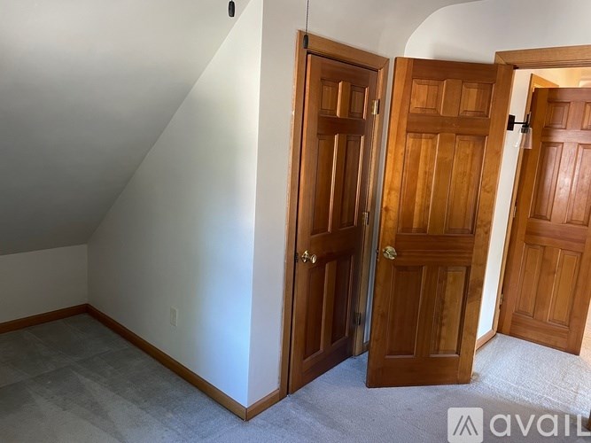A room with two wooden doors and a carpeted floor.