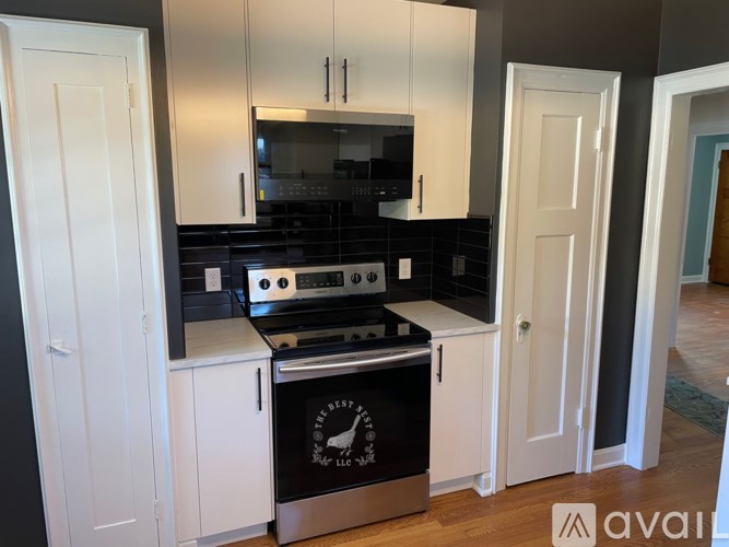 A kitchen with black and white cabinets and a stove top oven.