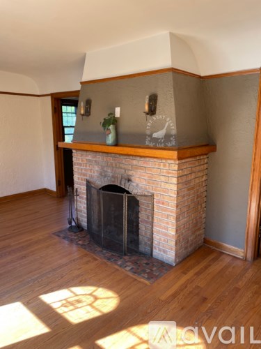 A fireplace with a wooden mantle and a plant on top.