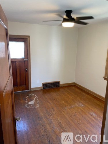 A room with a wooden floor and a ceiling fan.