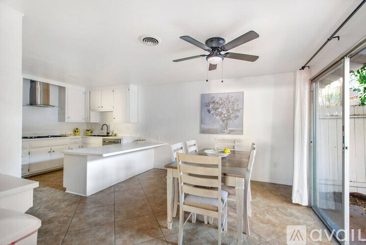 A kitchen with a table and chairs in front of a window.