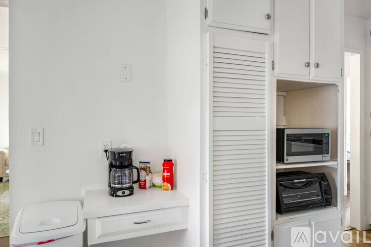 A kitchen with a coffee maker and a microwave on the counter.