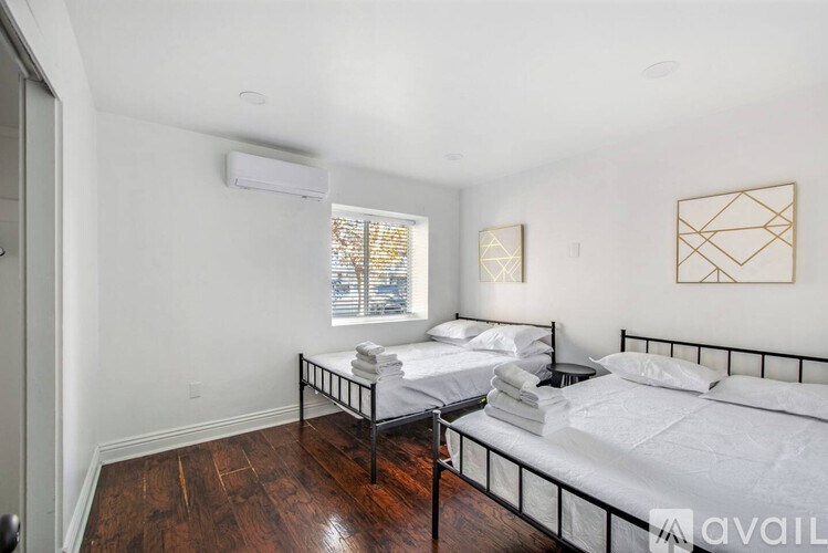 A bedroom with two beds and a window.