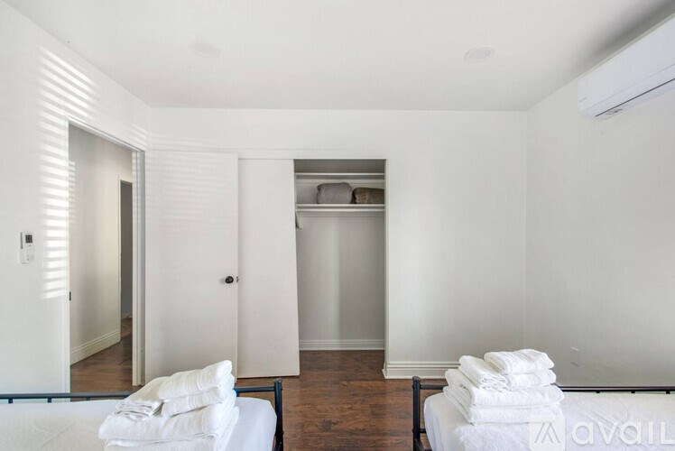 A room with a bed and towels stacked on top of it.