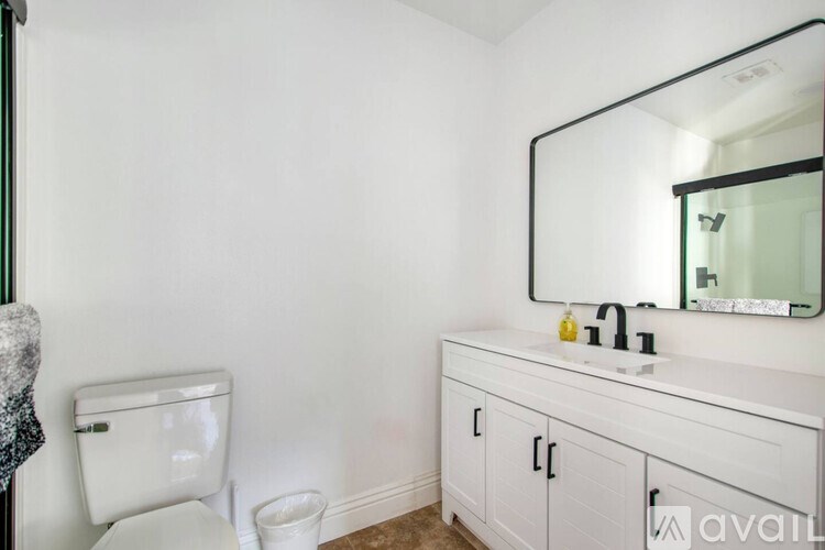 A bathroom with a white toilet and a white sink cabinet.