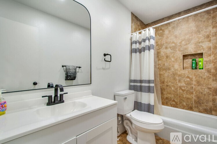 A bathroom with a white sink, toilet, and a mirror.