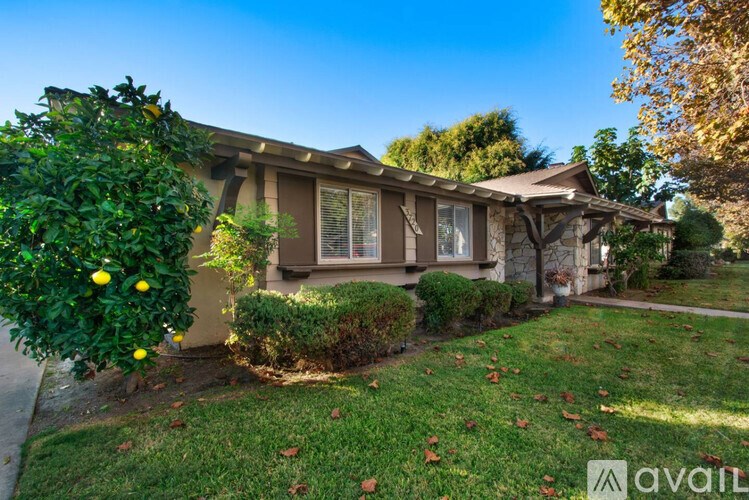A house with a brown exterior and a green lawn.