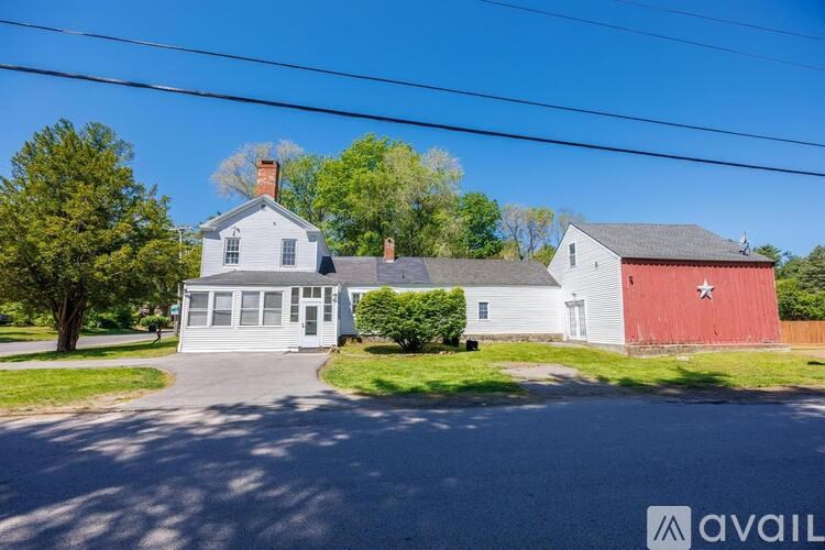 A house with a red barn is available for sale.