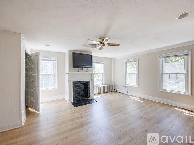 A spacious living room with a fireplace and a television.