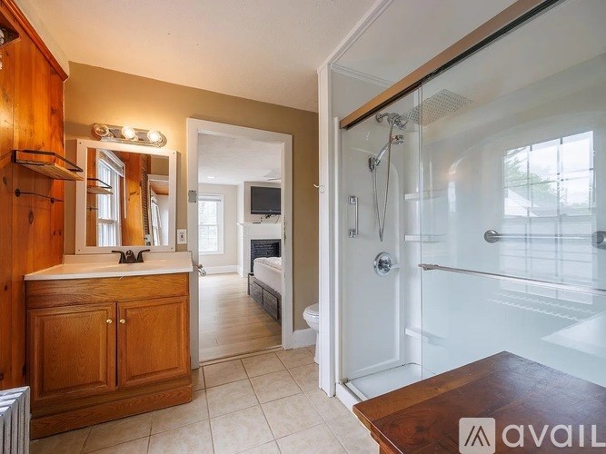 A bathroom with a walk-in shower and a wooden vanity.