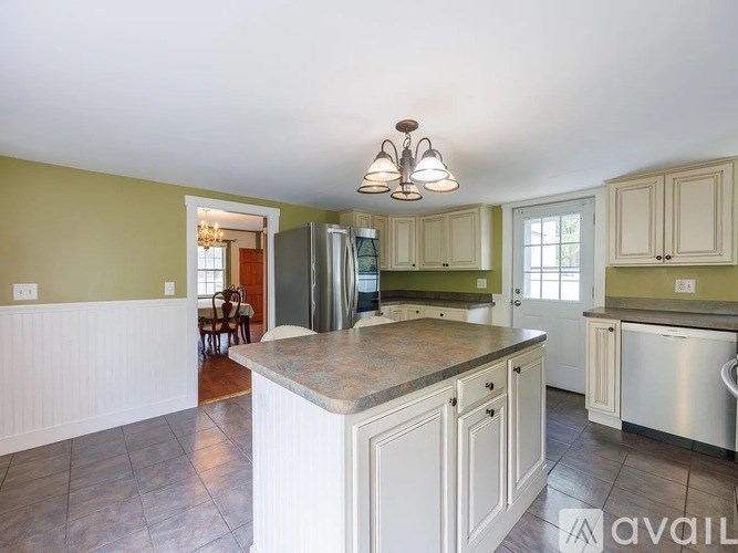 A kitchen with a large island and stainless steel appliances.
